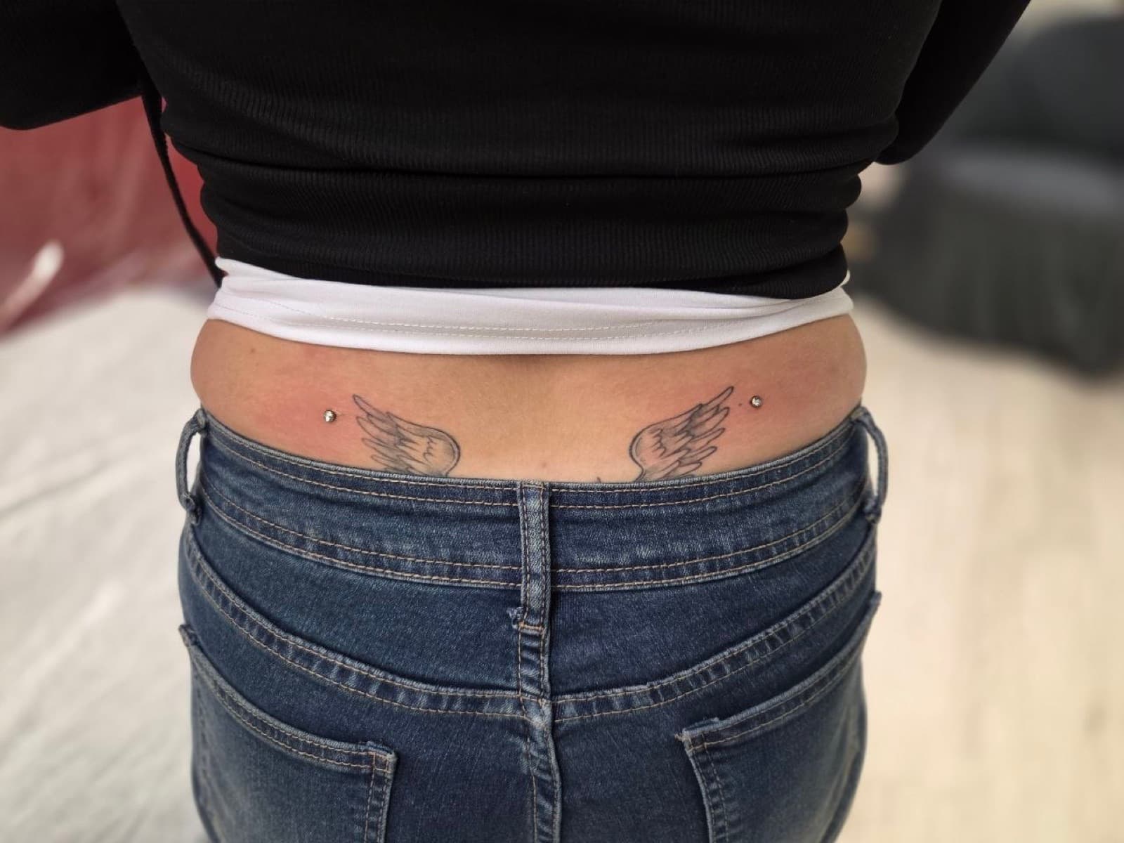 Pair of surface dermal piercings on the lower back