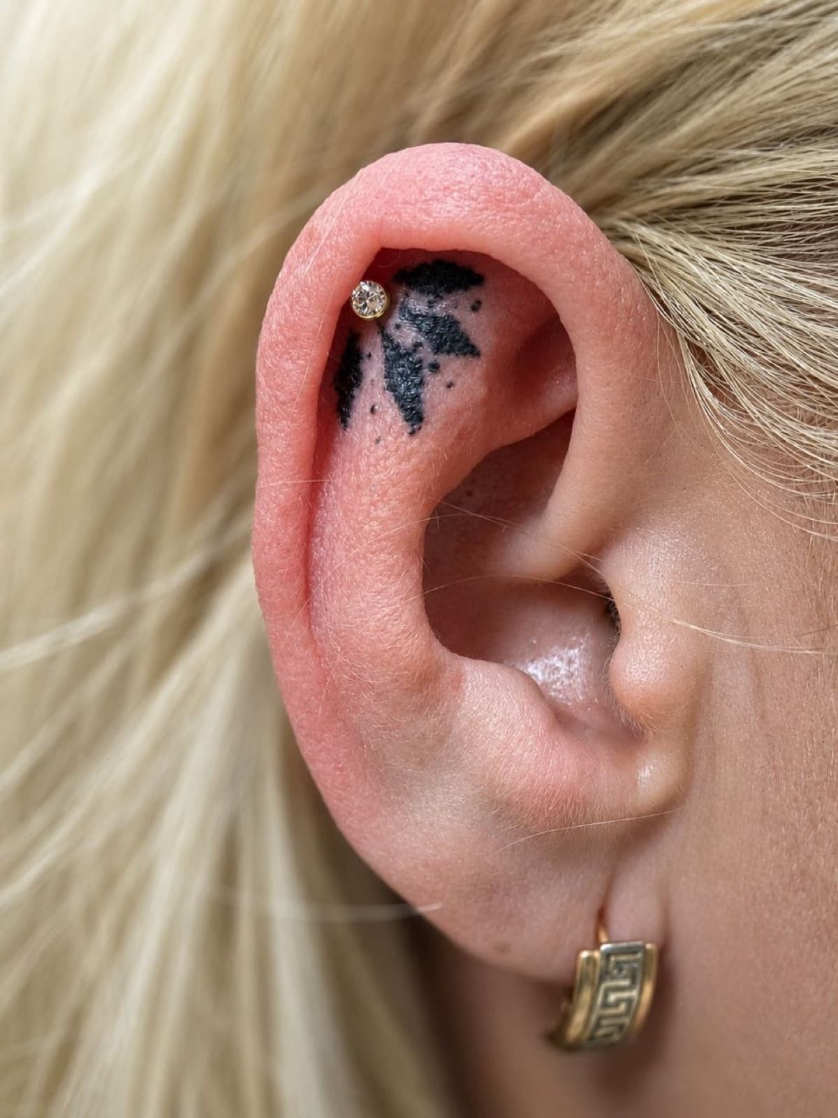 Helix piercing with a crystal stud and gold hoop
