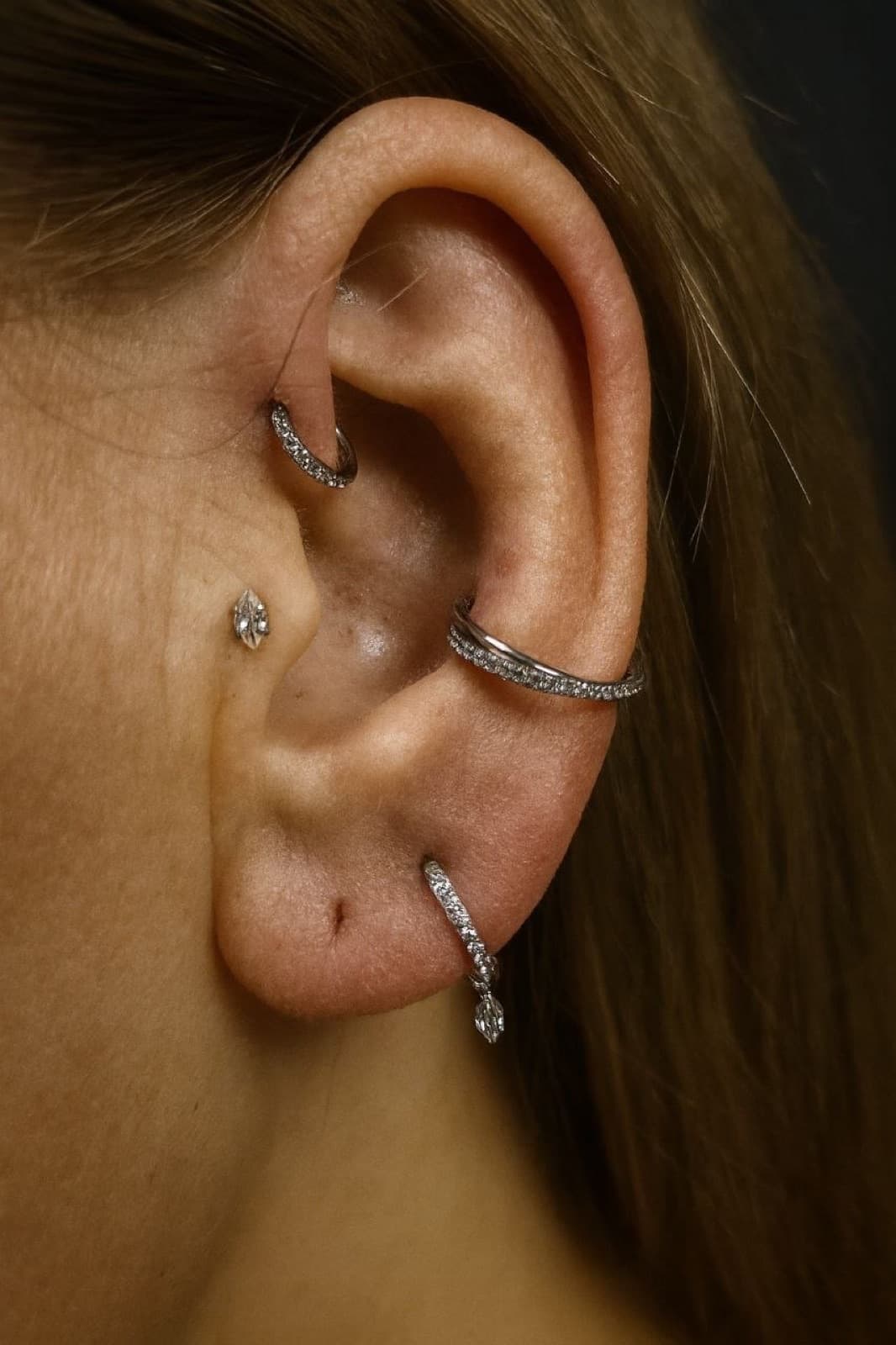 Helix, tragus and lobe piercings with hoop and stud earrings