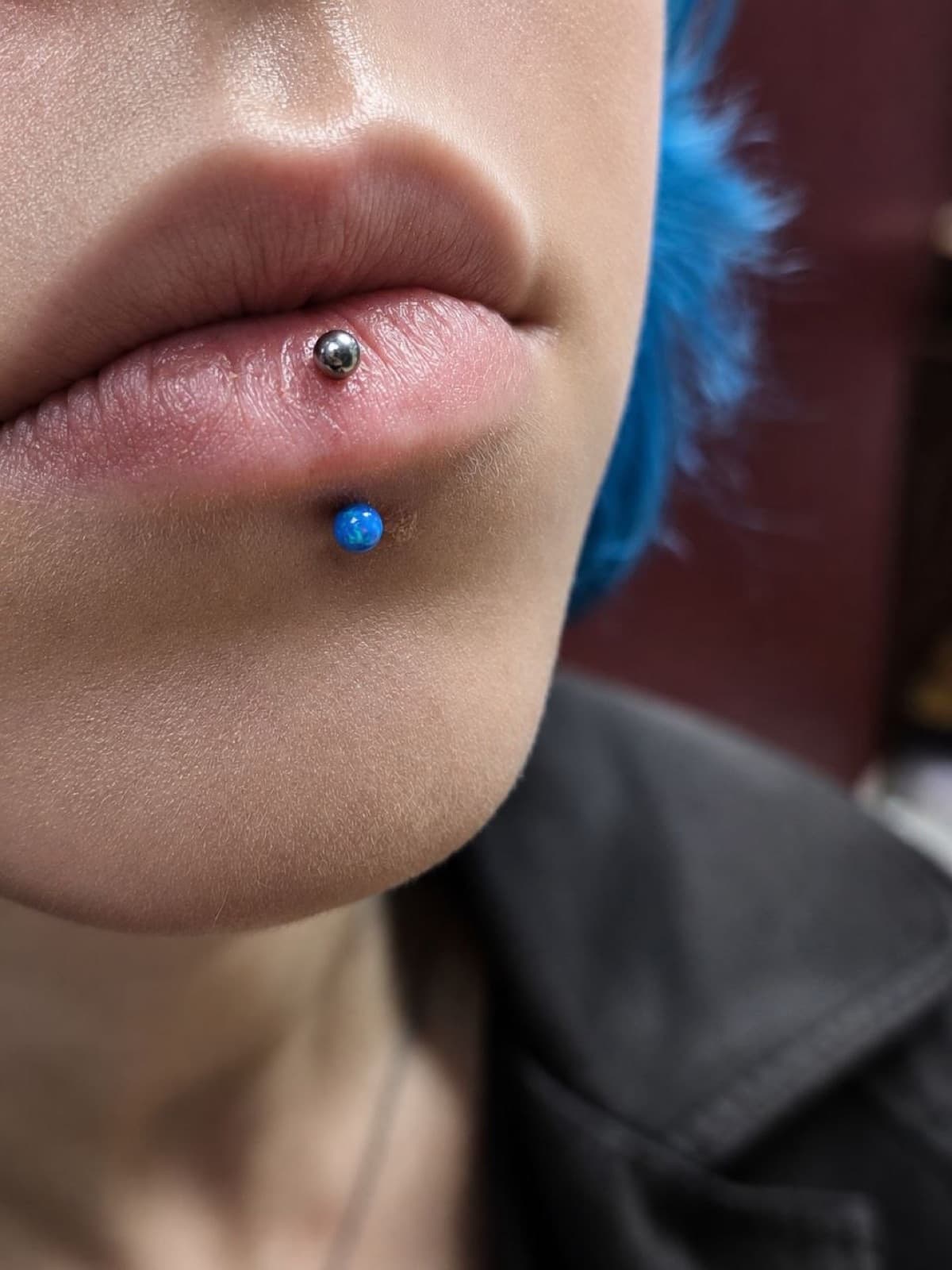 Labret lip piercing with a blue opal bead