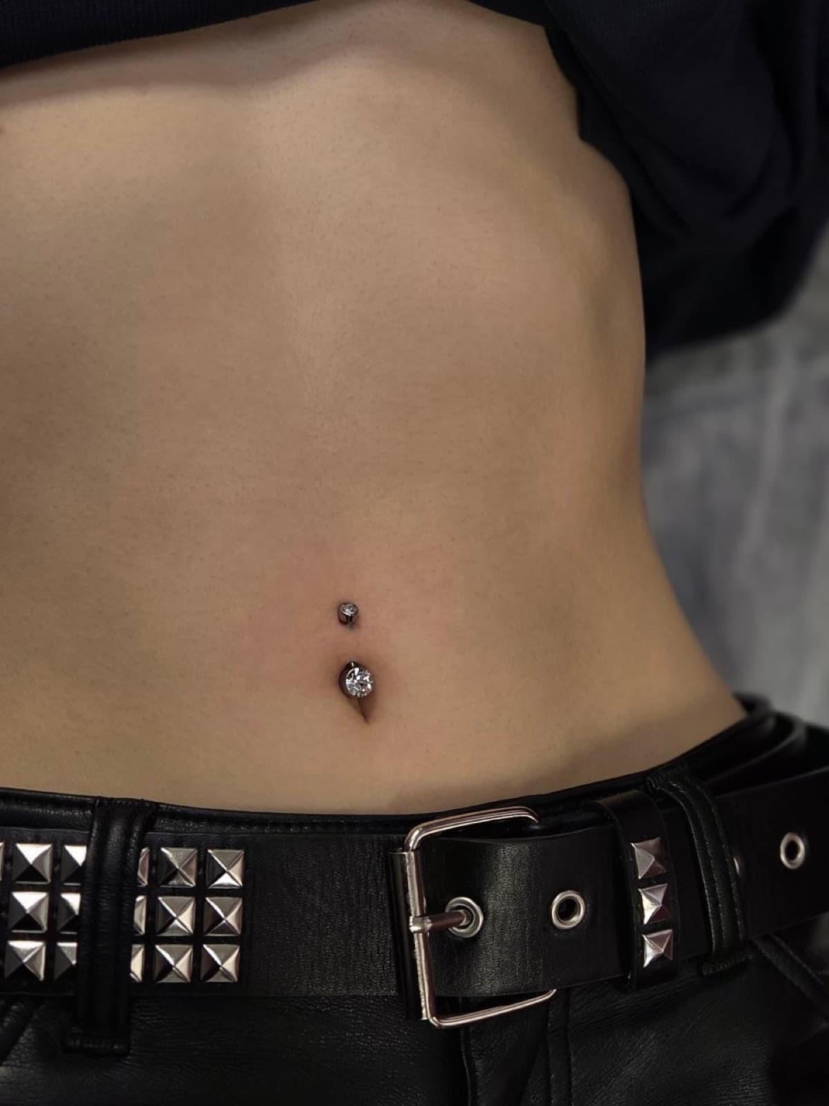 Navel piercing with a black gem curved barbell