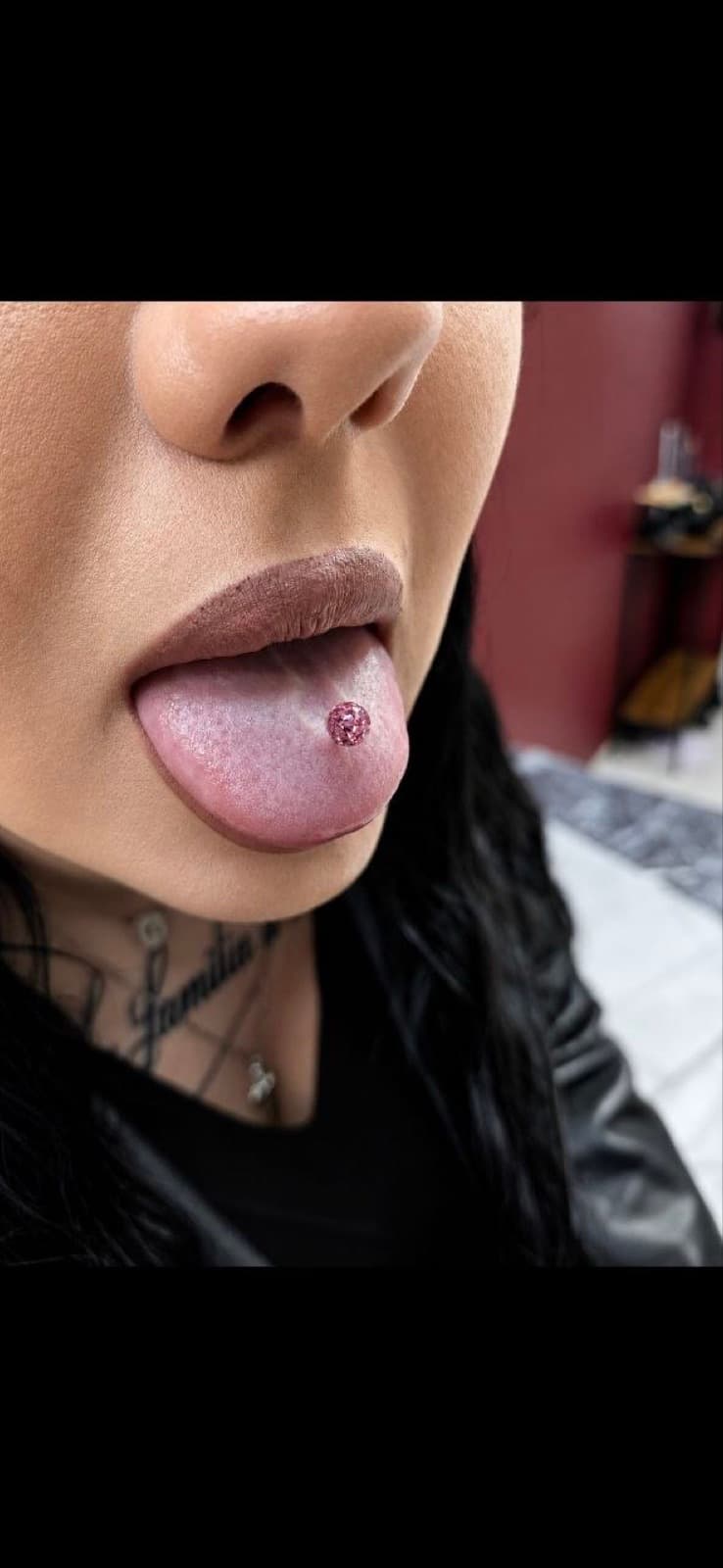 Tongue piercing with a pink gem barbell