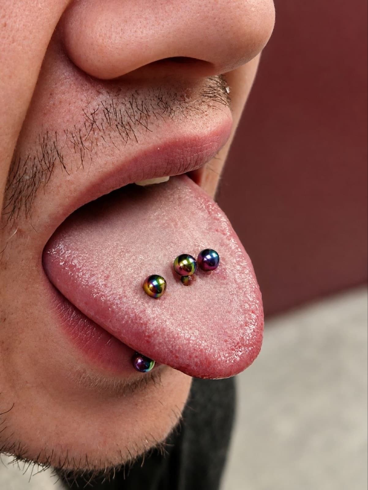 Triple tongue piercing with rainbow titanium balls